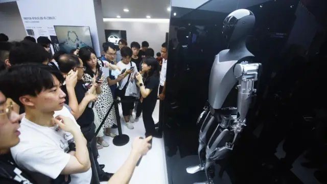 Visitantes conferem o robô humanoide Optimus da Tesla, exposto na Conferência Mundialvbet aviatorInteligência Artificialvbet aviatorXangai, na China