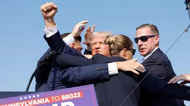 Donald Trump shows clenched fists during evacuation