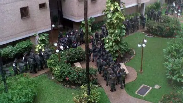 Decenas de efectivos de la GNB en un jardín junto a un edificio.