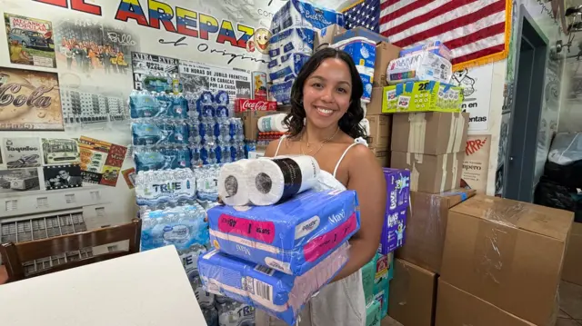 Vianna Martínez sostiene donaciones y las organiza en el restaurante venezolano El Arepazo, el 25 de junio de 2025 en Doral, Florida. 