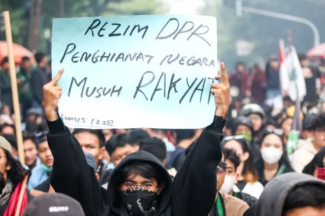 Seorang mahasiswa memegang poster protes saat berunjuk rasa menolak revisi undang-undang pilkada di depan Gedung Dewan Perwakilan Rakyat Daerah (DPRD) Jawa Barat di Bandung, Indonesia, pada 23 Agustus 2024.