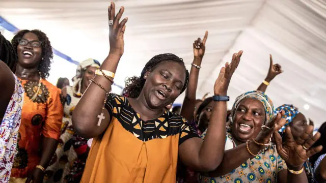 Mulheres dançam em uma igreja católica no Senegal