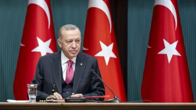 Erdoğan oturuyor gülüyor