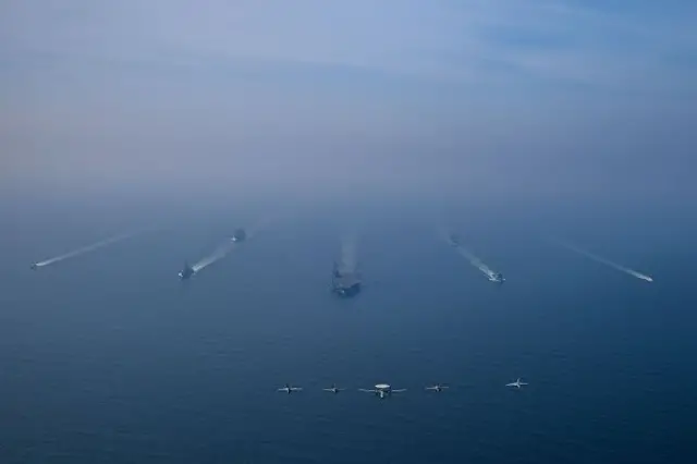 تصویری هوایی از ناوگروه ضربتی ناو هواپیمابر «یواس‌اس آبراهام لینکلن» در خاور میانه در حالی که جنگنده‌ها هم بر فراز آن در حال پروازند