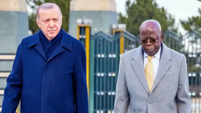Turkiye President President Recep Tayyip Erdoğan and Nigeria President Bola Tinubu. Erdoğan wear blue shirt and blue jacket, while Tinubu wear white shirt, yellow tie and grey jacket.