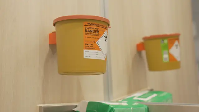 Урна для гострих предметів на стіні однієї з ін'єкційних кабін