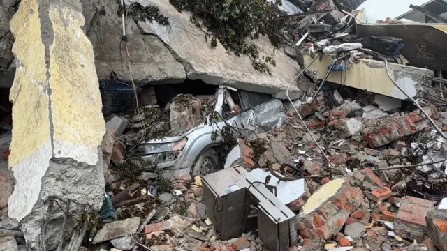 मलबे में दबी एक कार