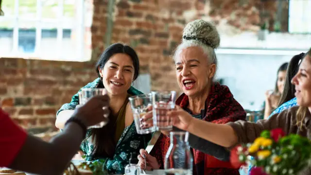 Un grupo de mujeres de distintas edades brindando.