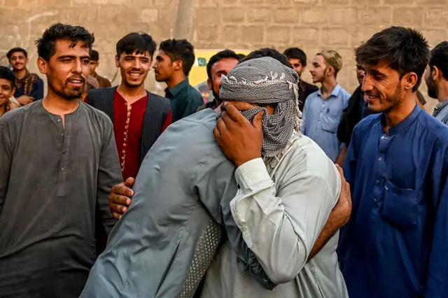 8 Nisan tarihinde Pakistan'ın Karaçi kentinden ayrılırken birbirine sarılarak ağlayan iki Afgan göçmen