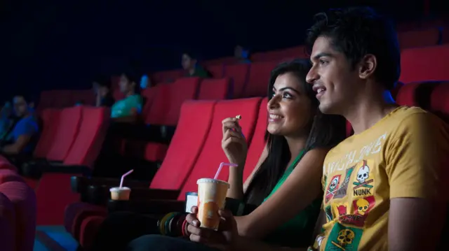 हॉल में सिनेमा देखते लोग