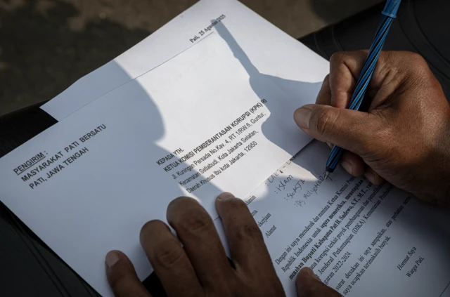 Seorang warga menulis surat berisi desakan kepada Komisi Pemberantasan Korupsi (KPK) terkait dugaan korupsi Bupati Pati Sudewo untuk dikirimkan melalui Kantor Pos Pati di Kabupaten Pati, Jawa Tengah Senin (25/08).