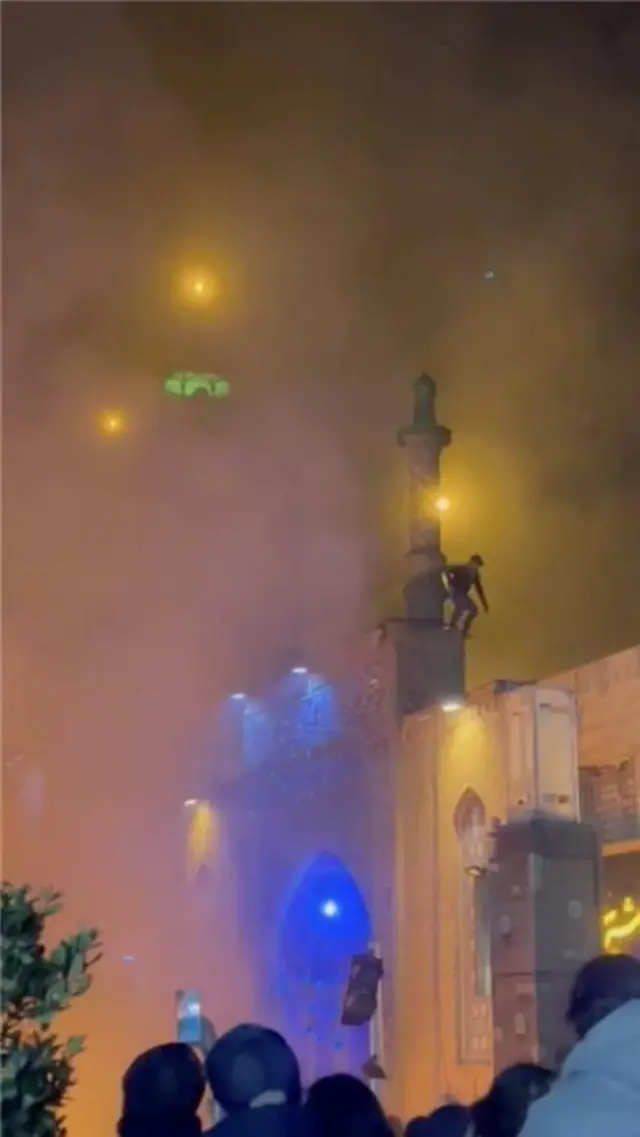 एक तस्वीर सामने आई है जिसमें कथित तौर पर सादतबाद इलाके में एक मस्जिद को आग लगाई जा रही है