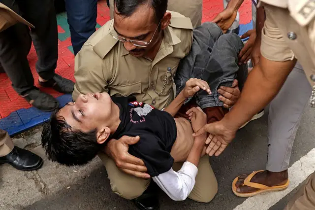 আহত এক ক্রিকেটপ্রেমীর শুশ্রূষা করছেন পুলিশ সদস্যরা