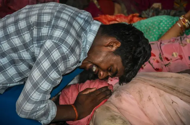 প্রিয়জনের মৃতদেহের সামনে কান্নায় ভেঙ্গে পড়ছেন এক ব্যক্তি