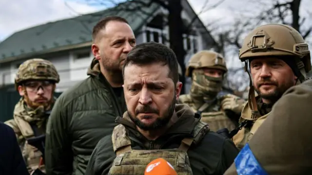 O presidente ucraniano, Volodymyr Zelensky (centro), fala à imprensa na cidade de Bucha