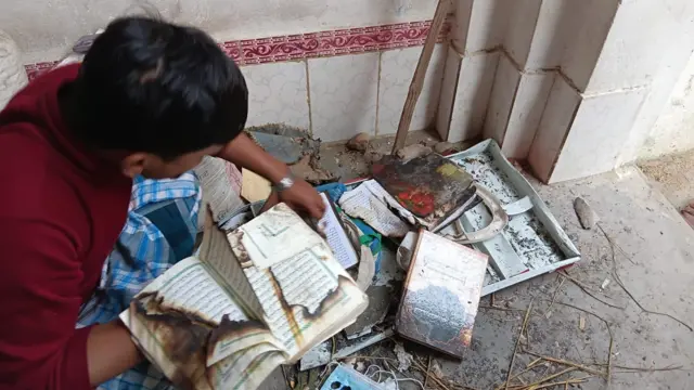 मौलाना अब्दुल अजिम सखुवामडानस्थित मस्जिदमा जलाइएका धार्मिक ग्रन्थहरू हेर्दै। 