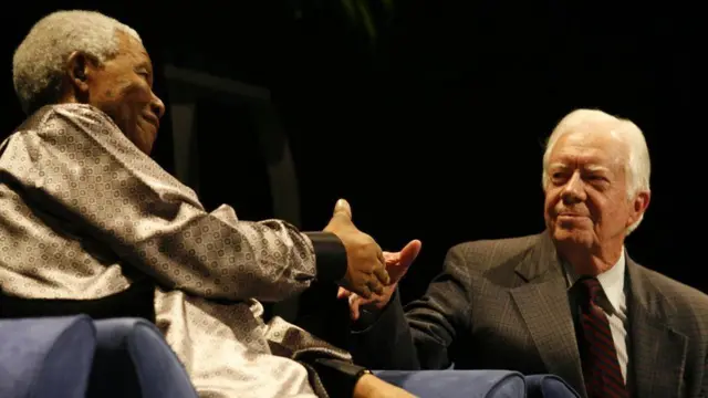 Nelson Mandela and Jimmy Carter about to shake hands.