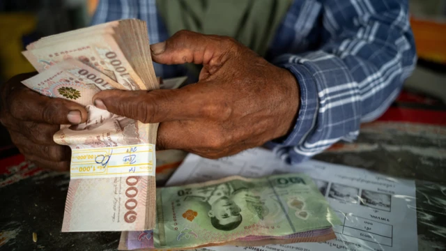 La main d'un homme qui compte des billets de banque