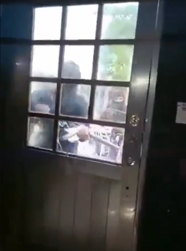 Imagen del video del secuestro en el que se ve a unos encapuchados derribando la puerta de la vivienda de la periodista.
