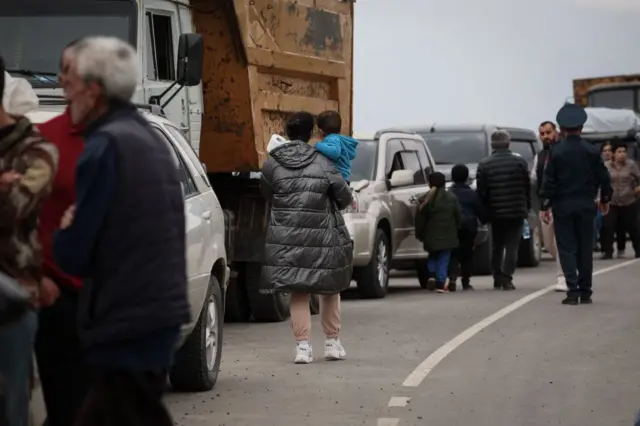 Los refugiados esperando después de cruzar la frontera y llegar a un centro de registro del Ministerio de Asuntos Exteriores de Armenia, cerca de la ciudad fronteriza de Kornidzor.