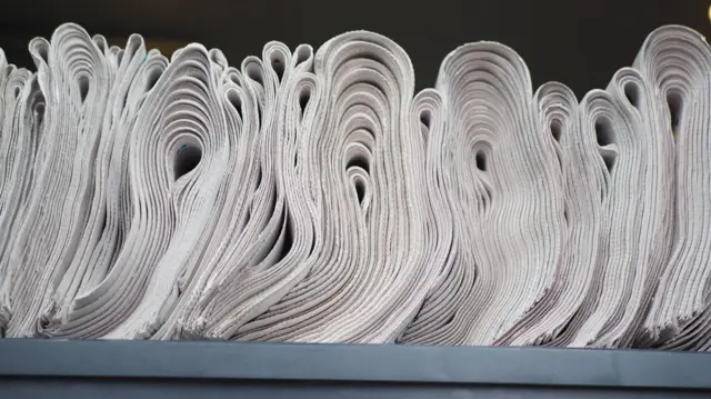 টেবিলে রাখা পত্রিকার স্তুপ 