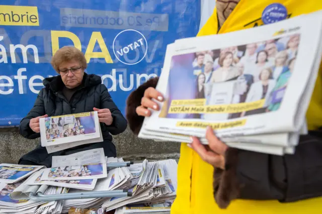 A woman prepares to share election leaflets campaigning for Maia Sandu