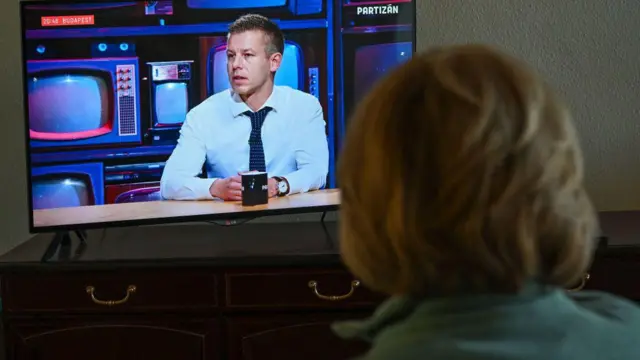 14 февраля 2024 года в Будапеште (Венгрия) женщина смотрит онлайн-трансляцию телепрограммы, в которой в интервью выступает инсайдер правительства Петер Мадьяр, бывший супруг экс-министра юстиции 