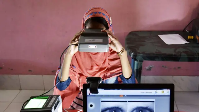 आधार के लिए बायोमेट्रिक जानकारी देती हुई महिला