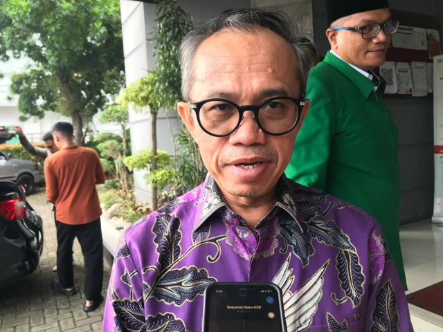 Rektor Universitas Andalas, Efa Yonnedi terlihat sedang dalam wawancara tatap muka dengan menggunakan baju batik berwarna ungu dan berkacamata.