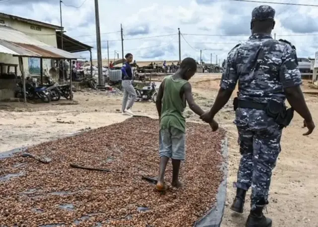 Un agent de sécurité tenant un enfant à la main