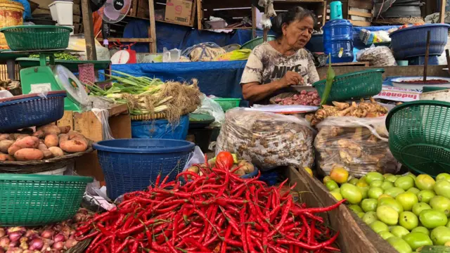 Mayar, pedagang sayuran di Pasar Raya Padang berusaha menjual bahan-bahan pokok.