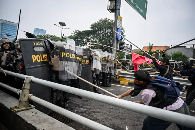Personel polisi menghalau pengunjuk rasa di Jalan Letjend S Parman, depan Gedung DPR, Jakarta, Senin (25/08)