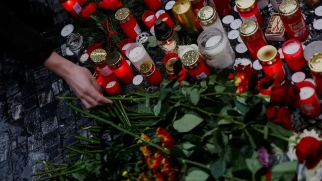 شخص يضيء شمعة في ضريح رمزي بعد إطلاق نار في العاصمة التشيكية براغ، وتحاول الشرطة معرفة الدوافع في أسوأ حادث لإطلاق النار بشكل جماعي في البلاد، حين فتح طالب النار داخل حرم الجامعة، ليقتل 14 شخصا ويصيب 25 أخرين.