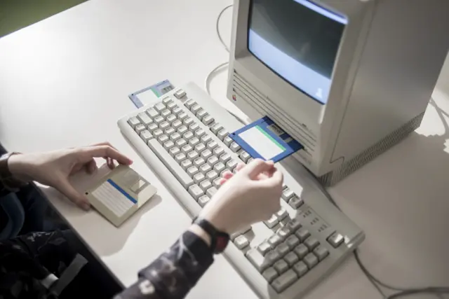 A member of staff shows Macintosh SE FDHD