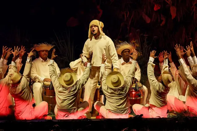 Bad Bunny durante una presentación rodeado de bailarines vestidos como campesinos puertorriqueños.