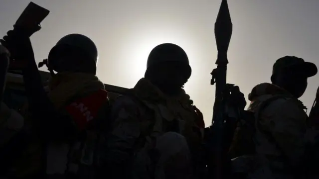 Aworan awọn ọkunrin mẹta ti wọn mura bii ologun, gbe nnkan ija dani ninu ọkọ ti wọn wa. Gbogbo rẹ dudu birimu