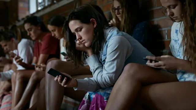 ስልካቸውን በአትኩሮት የሚመለከቱ ወጣቶች