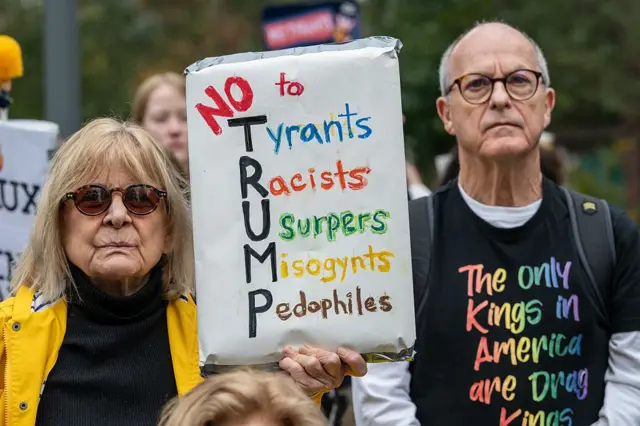 18 Ekim'de Londra'daki ABD Büyükelçiliği binası önünde yapılan eylemde yan yana duran iki protestocu