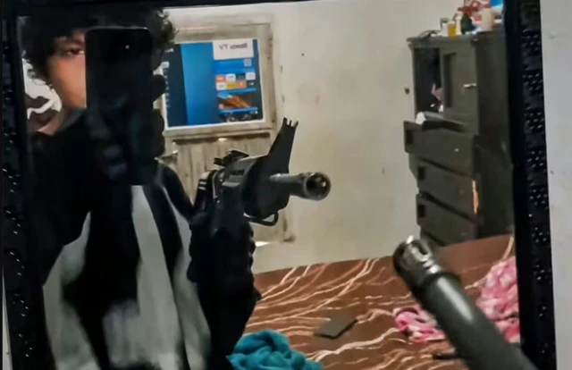 Osmer H se graba mientras prota un rifle en su habitación