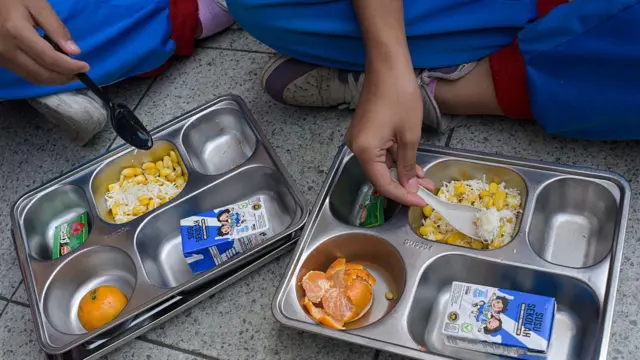 Foto yang menunjukkan para siswa sedang menyantap makanan yang disediakan oleh program makan gratis di SD Cilengkrang, Bandung, Jawa Barat.