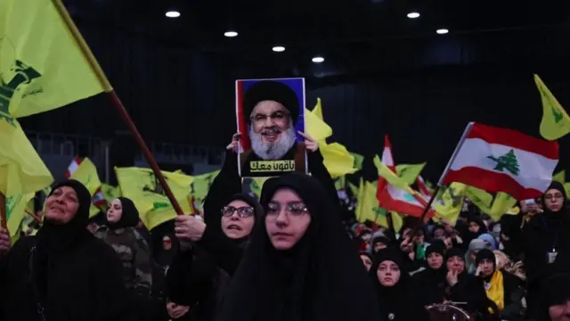 Simpatizantes de Hezbolá con banderas del grupo y de Líbano, y una foto de Hassan Nasrallah.