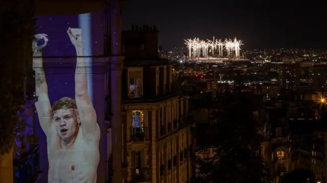 Una proyección de León Marchand con el estadio olímpico atrás