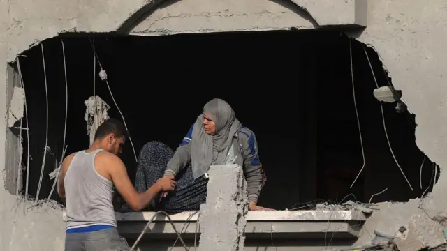 ဂါဇာတောင်ပိုင်းက ရာဖာကို အစ္စရေးလေကြောင်းတိုက်ခိုက်မှုအပြီး အဆောက်အအုံအပျက်အစီးတွေထဲကနေ ထွက်ခွာဖို့ ကြိုးစားတဲ့ အမျိုးသမီးကြီးတစ်ဦးကို ပါလက်စတိုင်း အမျိုးသားတစ်ဦးက ကူညီပေးနေတာဖြစ်ပါတယ်