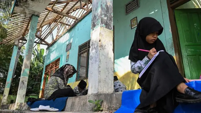 Siswa belajar di emperan gedung sekolah yang rusak d