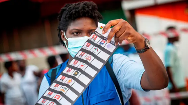 EC official dey sort out a ballot paper