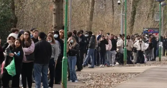 Люди стоять у черзі 