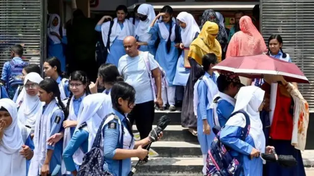 রোদে অনেকগুলো নারী শিক্ষার্থী দাঁড়িয়ে