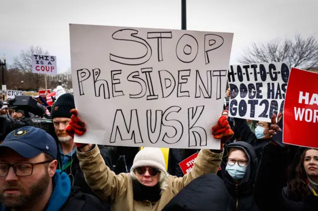 Manifestantes con carteles contra Elon Musk.