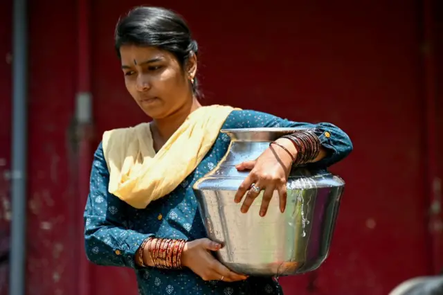 पानी भरकर ले जाती हुई एक महिला