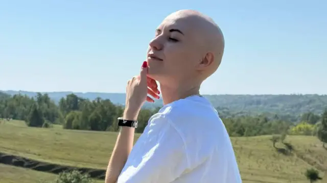 Лиса дівчина в білій футболці на фоні природи